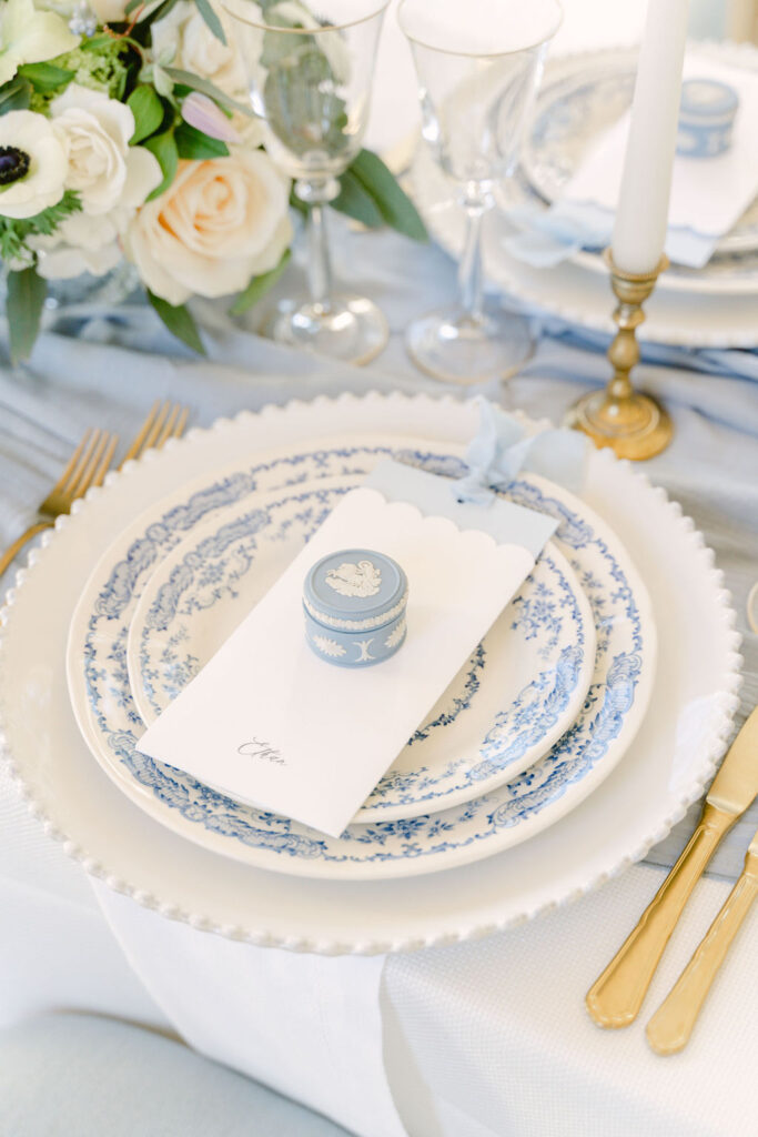 A close up of the blue Wedgwood trinket box fine art wedding favours resting upon the menu at each guest's place setting.