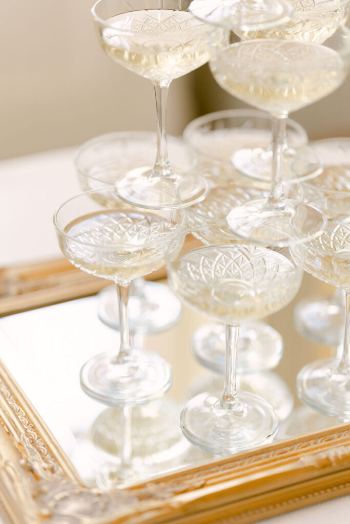 A close up of the champagne tower on top of an ornate gold-framed mirror.