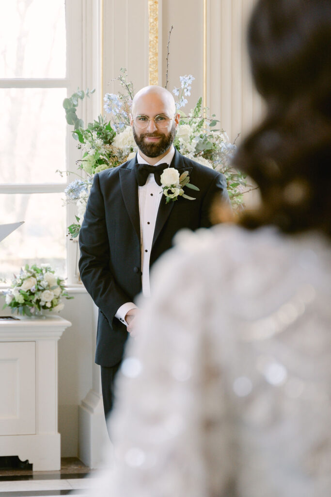 The groom smiles as he awaits his bride.